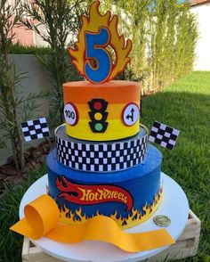 a three tiered cake with cars and numbers on it