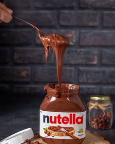 a jar of nutella is being dipped with chocolate