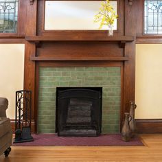 a living room with a fire place in the center and stained glass windows above it