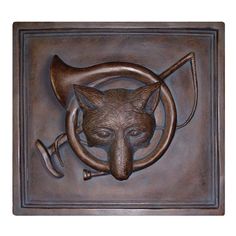 a metal plaque with a cat's head and an arrow on the front side