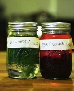 two jars filled with liquid sitting on top of a wooden table