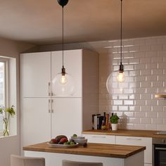 a kitchen with white cabinets and wooden counter tops