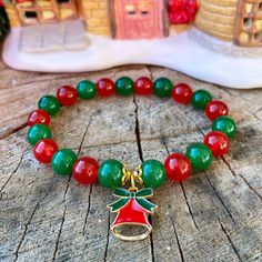 This handmade gemstone bracelet is made from genuine 8mm Green Jade beads and 8mm Red Jade beads, and is strung on a high quality stretch cord. This natural gemstone bracelet is a beautiful gift idea for the Christmas season, as a stocking stuffer, or a gift for yourself.  Please see picture 8 to determine your ideal bracelet length in order for the bracelet to be made to fit nicely around your wrist.  Please note that if you would like the bracelet to fit snug around your wrist then measure with the measuring tape tightly around your wrist. If you prefer a bit of a loose fit then order 1/2 inch bigger (ex: my wrist measures 6 inches tightly, but I prefer a bit of a looser fit so I would order a 6.5 inch bracelet).  Please see picture 7 to determine which Christmas charm you would like on Christmas Beaded Jewelry, Holiday Bracelets, Crystal Bead Jewelry, Red Jade, Bracelet Inspo, Bracelet Christmas, Christmas Bead, Christmas Bracelet, Christmas Charms