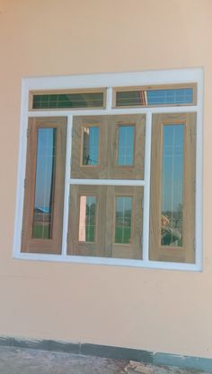 a cat sitting on the window sill in front of a house that is being built