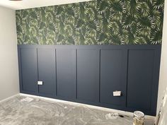 a room that has some paint on the walls and is being painted with palm leaf wallpaper