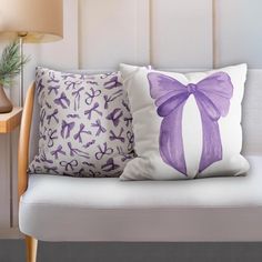 two pillows with bows on them sit on a bench next to a lamp and table