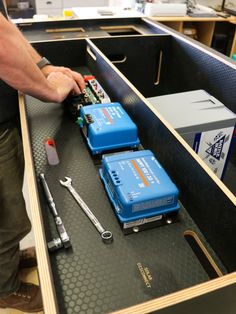 two blue boxes sitting on top of a table next to some tools and other items