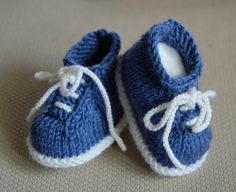 a pair of blue knitted baby shoes with white laces