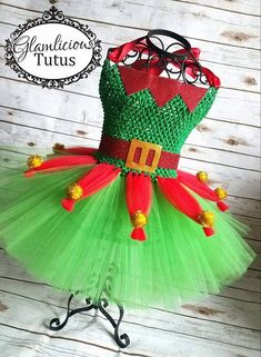 a green and red tutule dress sitting on top of a metal stand