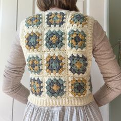 a woman wearing a crocheted vest with flowers on it