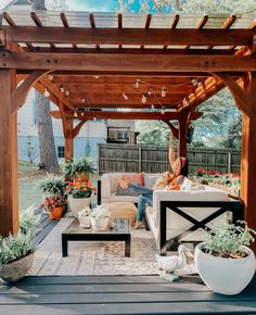 an outdoor living area with couches, tables and potted plants