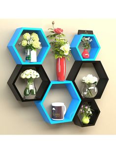 an arrangement of vases, flowers and other items are arranged in hexagonal shelves