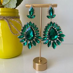 These fun, chic and fashionable emerald green rhinestones earrings are a great statement piece elevating your outfit to the next level. Be ready to receive compliments and look your best!  Dimensions:  Length: Approx 3.5" Width: Approx 2" Select your products carefully as no returns or exchanges are accepted. This piece is in perfect condition as you see on the picture. Once chosen and approved by the customer before shipment, the order is completed. All sales are final. Contact seller should you have any questions or doubts. Seller is not responsible for lost or stolen packages.   ----------------------------------------------------------------------------------------------------------------------------------------------- Estos divertidos, elegantes y modernos aretes de diamantes de imita Green Dangle Earrings, Pageant Earrings, Evening Earrings, Green Prom, Prom Earrings, Party Earrings, Earrings Green, Look Your Best, Rhinestone Earrings