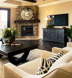 a living room filled with furniture and a flat screen tv mounted on the wall above a fireplace