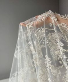 the back of a wedding veil with white flowers on it