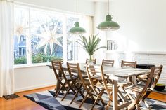 a dining room table and chairs in front of a large window