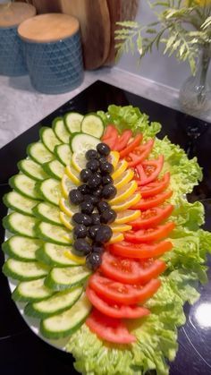 a platter filled with sliced vegetables and olives