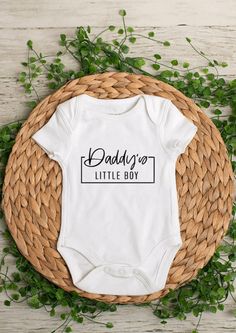 Daddy's Little Boy Shirt or Baby Bodysuit.  *When ordering: SS = Short Sleeve, LS = Long Sleeve *Bodysuits are Carter's brand. Please see their sizing chart if you aren't sure what size to order. *All bodysuits/t-shirts are white. The color you choose is for the text/image.  *If you would like a colored bodysuit or shirt, please request a custom order and we can see if we can meet your needs. Please note though that there is usually an added charge for this. *Each design is professionally cut an White Unisex Short Sleeve Onesie, White Short Sleeve Bodysuit With Graphic Print, White Fitted Short Sleeve Bodysuit With Graphic Print, Father's Day Cotton Onesie With Graphic Print, White Short Sleeve Bodysuit With Letter Print, Cotton Onesie With Letter Print For Gender Reveal, Family Matching Cotton Onesie With Short Sleeves, Father's Day Casual Short Sleeve Onesie, Casual Personalized White Onesie