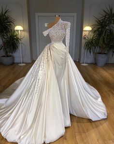 a white wedding dress on display in a room