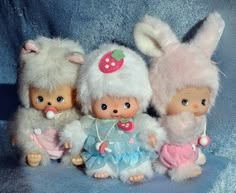 three little dolls are posed next to each other wearing bunny ears and dresses, one is dressed as a rabbit