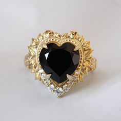 a gold ring with a black heart surrounded by diamonds