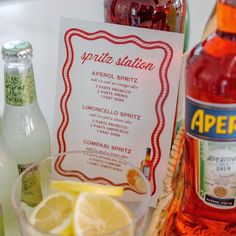 a bottle of aperitze sitting on top of a table next to some lemon wedges