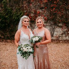 two bridesmaids pose for a photo in front of a stone wall