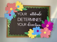 a chalkboard with flowers on it that says your attitude determines your direction and is decorated with paper flowers