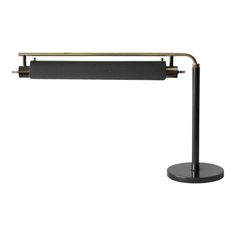 a black and gold desk lamp on a white background