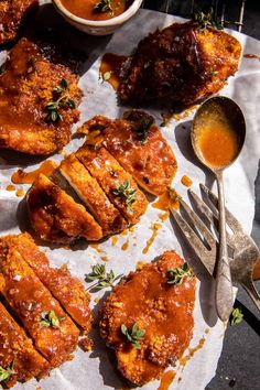 some food is laying out on top of a paper towel with spoons and sauce