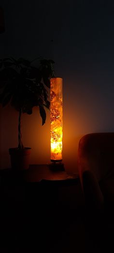 a lamp that is on top of a table in front of a chair and a potted plant