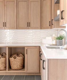 a kitchen filled with lots of wooden cabinets and white counter tops next to a sink