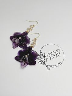 Real preserved orchid flower earrings grown in Hawaii. I can guarantee you'll never find another beautiful hand crafted pair of earrings like this. The earring hooks are dipped in gold embellished with clear glass accent charms. There are limited quantities available for it takes several months to preserve and create these gorgeous earrings. *All flowers are preserved by me. *Due to the nature of all flowers, each pair may not be the exact length, width or color but I pair them as close as possi Hawaiian Orchid, Orchid Earrings, Flower Dangle Earrings, Flowers Dried, Earrings Resin, Preserved Flowers, Resin Flowers, Orchid Flower, All Flowers