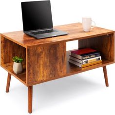 a laptop computer sitting on top of a wooden table next to a book shelf with books