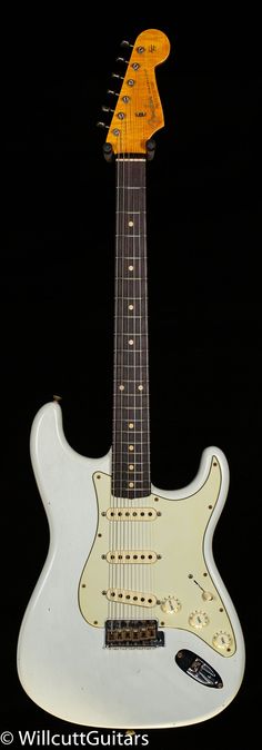 an electric guitar that is white and has yellow pickers on the top of it