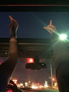 two people in a car with their hands up