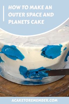 how to make an outer space and planets cake with blue icing on top, sitting on a wooden table