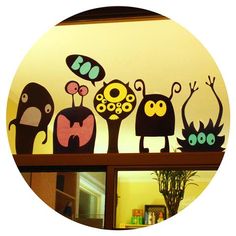 a group of cartoon monsters sitting on top of a shelf in front of a mirror