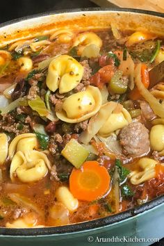 a bowl of tortellini soup with meat, noodles and vegetables is shown in the foreground