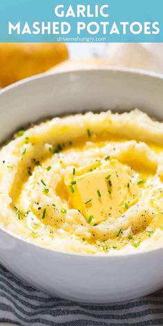 mashed potatoes in a white bowl with butter and parmesan cheese on top