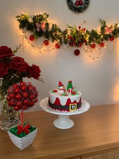 a decorated christmas cake sitting on top of a table next to a vase filled with flowers