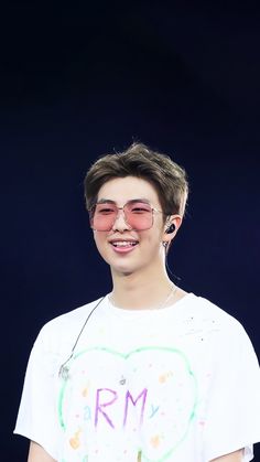 the young man is wearing headphones and smiling at the camera while standing in front of a black background