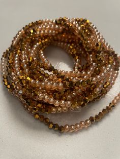 Elastic Waist Bead "Koun-Fao" crafted with resplendent gold glass crystal seed beads and adorned with delicate light brown glass seed bead accents. This elastic waist bead not only emanates opulence but also embodies a warm and earthy elegance, offering a comfortable and adjustable fit that transcends beauty and symbolism. 🌟 Gold Glass Crystal Seed Beads - Opulent Radiance: Koun-Fao is adorned with a luxurious array of gold glass crystal seed beads, creating an opulent radiance that symbolizes Brown Waist Beads, Waist Jewelry, Strong Hand, Waist Beads, Gold Glass, Glass Crystal, Bead Designs, Small Waist, Seed Bead