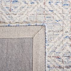 three different colored rugs on the floor, one with blue and white designs in it