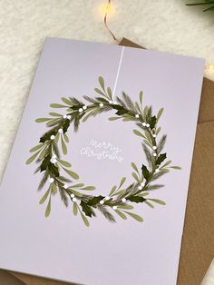 a christmas card with a green wreath on it