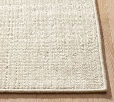 a white rug on top of a wooden floor with an area rug in the middle