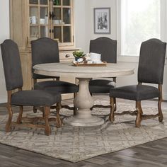 a dining room table with chairs around it and a rug on the floor next to it