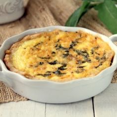 a casserole dish with spinach and cheese in it on a wooden table