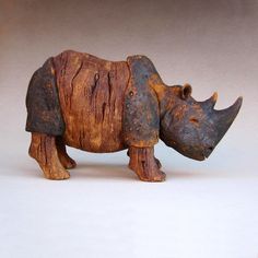 a wooden rhinoceros figurine on a white background