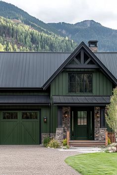 a green house with a black roof and two garages on the side of it